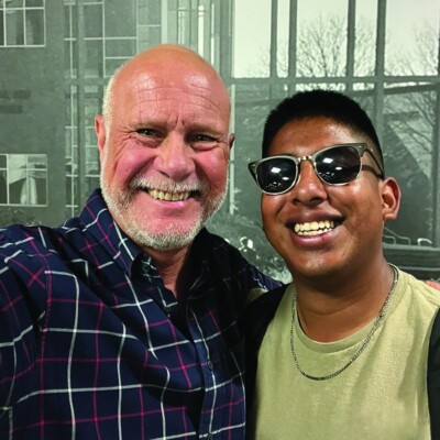 Larry and Caleb stand together smiling for the camera.