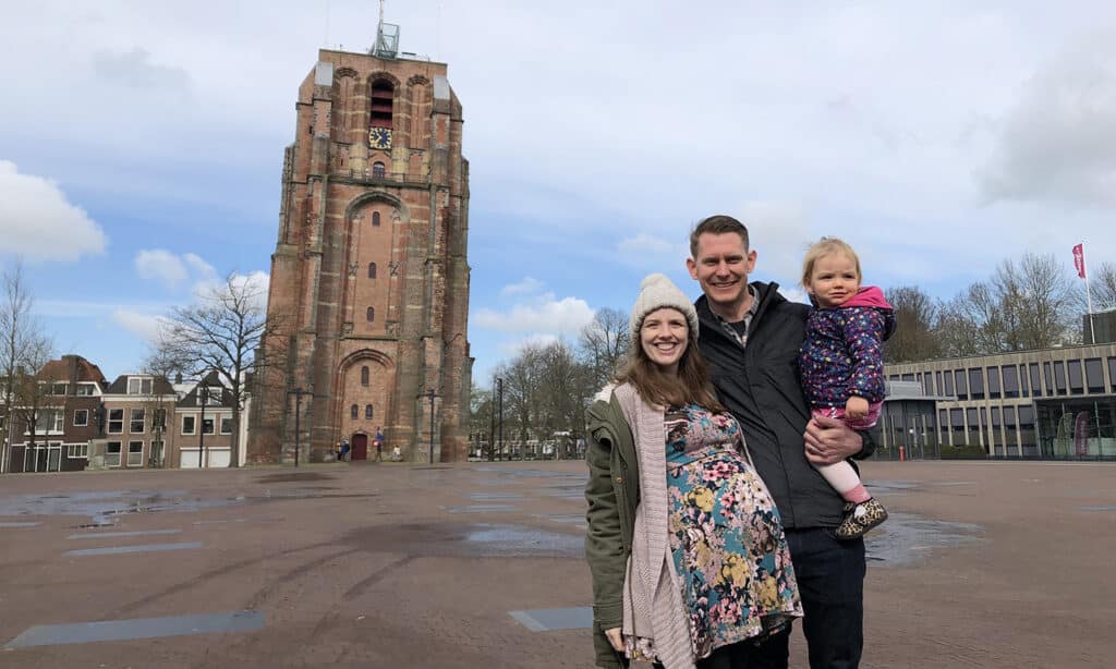 Joel and Libby stand with their daughter in front of the Oldehove tower in Leeuwarden.