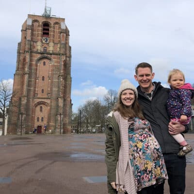 Joel and Libby stand with their daughter in front of the Oldehove tower in Leeuwarden