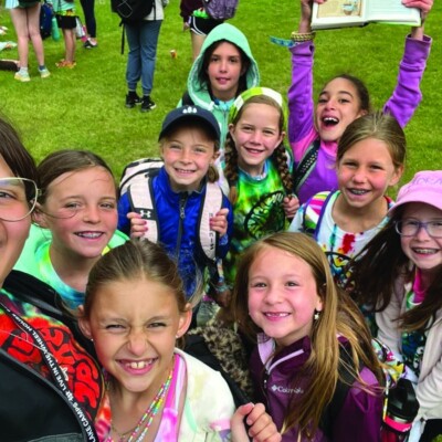 A group of kids from Eagle Lake Camp stand with their camp counselor.