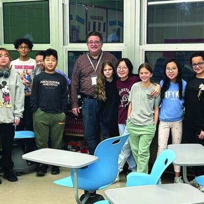 A group photo of middle school students in a classroom, participating in a Navigators Bible club.