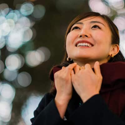 A portrait of a woman in an illuminated street at night.