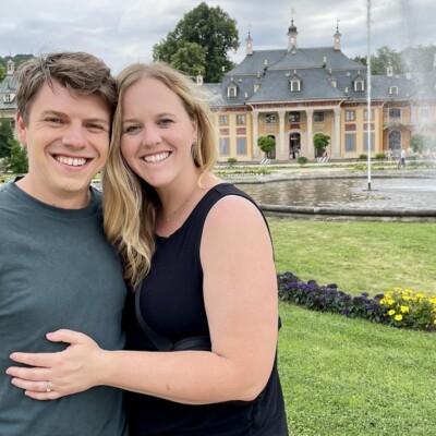 A man and woman posing in front of a fountain.