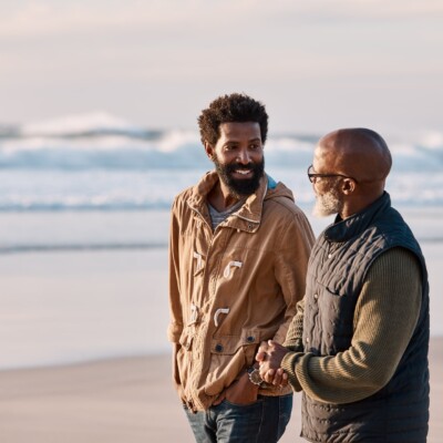 Shot of a young man going for a walk along the beach with his mentor