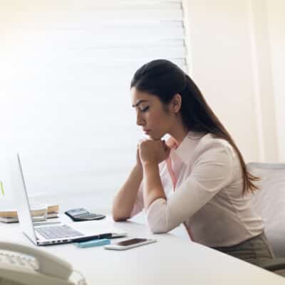 How to Pray Using the PRAY Method | Navigators Prayer Resources | Woman with clasped hands in prayer at an office desk